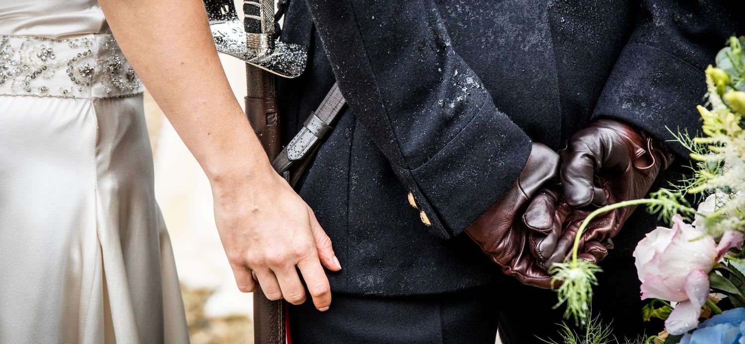 Close-up details of formal black attire and wedding accessories.