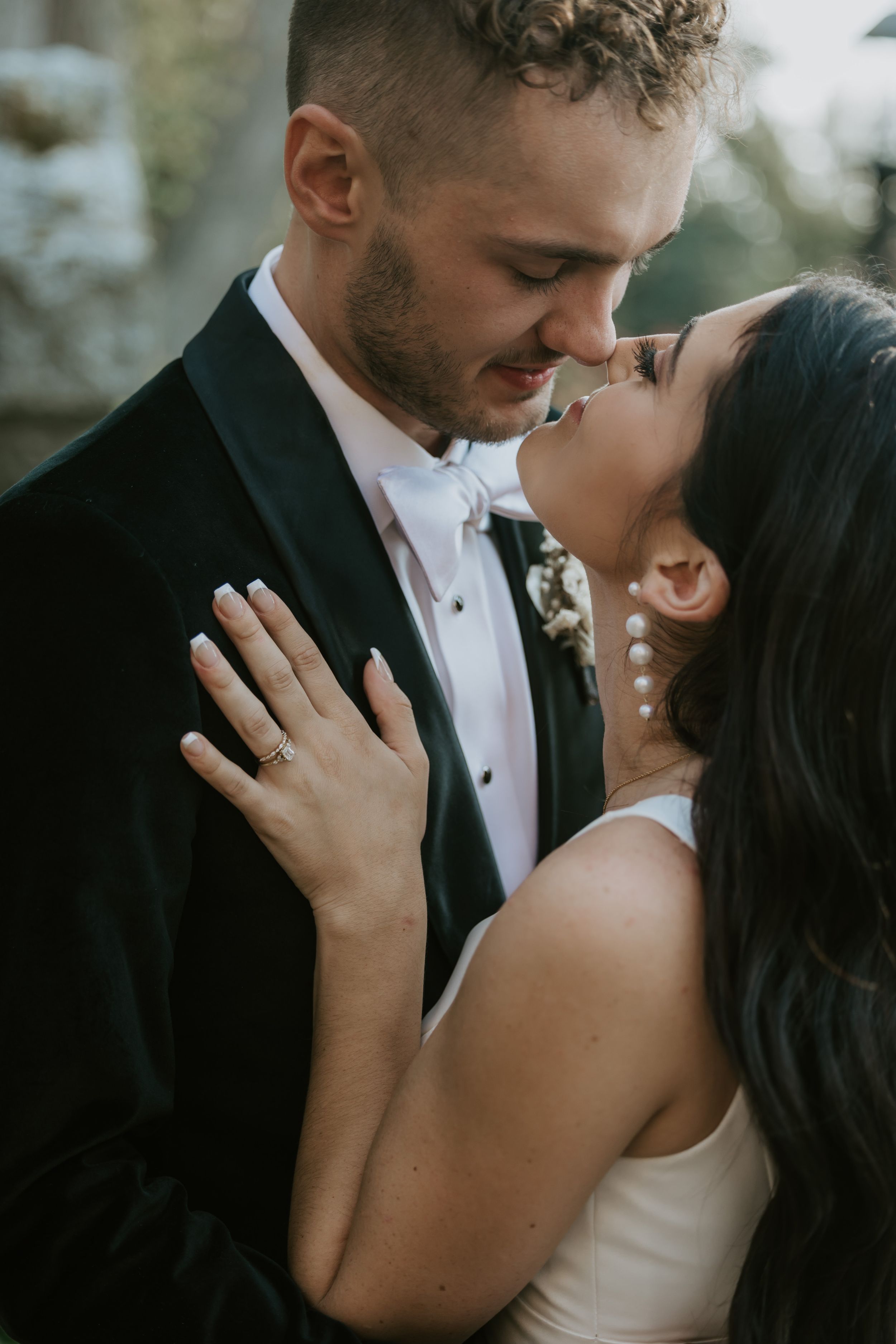 Intimate wedding portrait capturing romantic moment between couple with vintage manor backdrop.