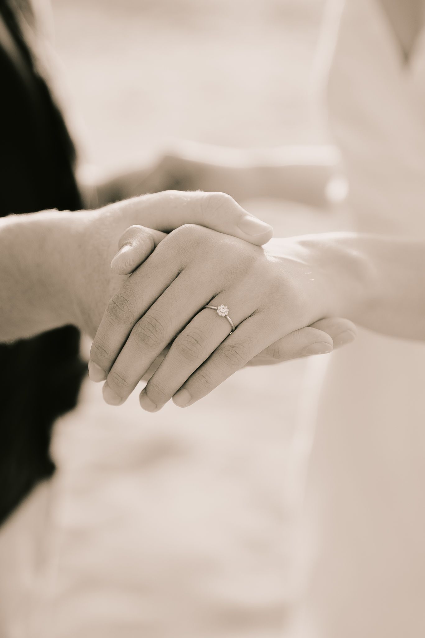 Engagement ring on hands holding together