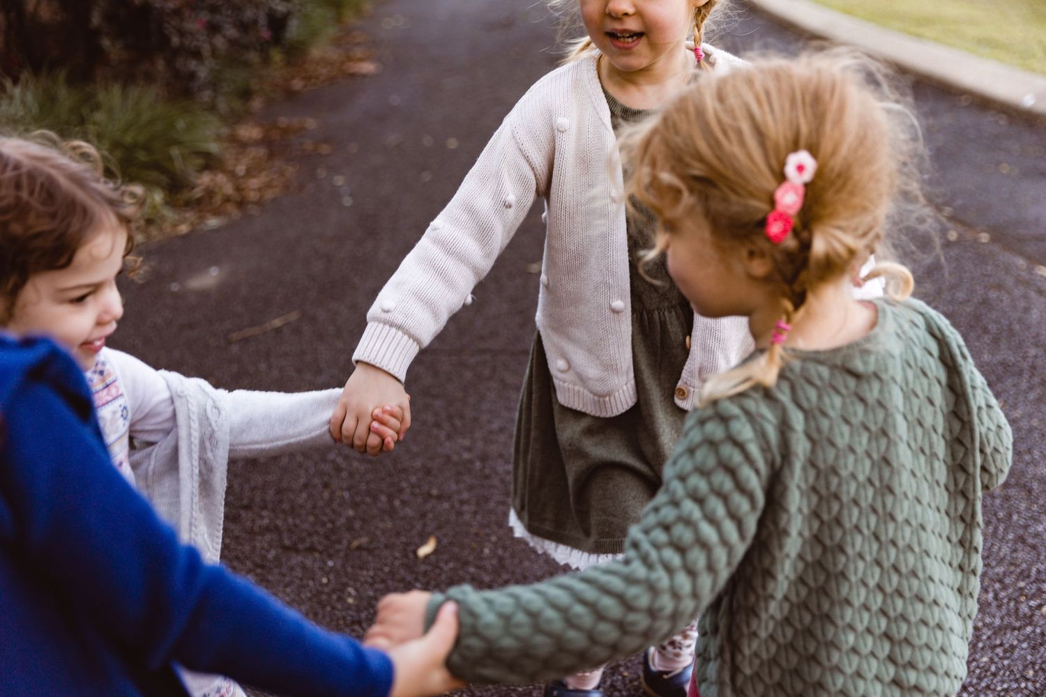 Children playing ring-a-rosy during a family photo shoot at Mt Coot-tha Botanic Gardens