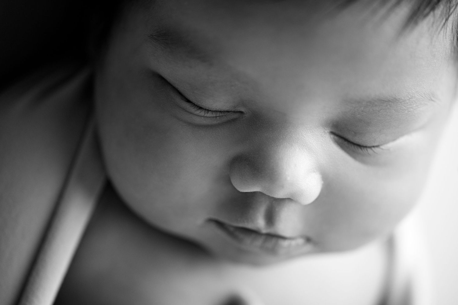 Artistic black and white macro close-up shots of newborn features.
