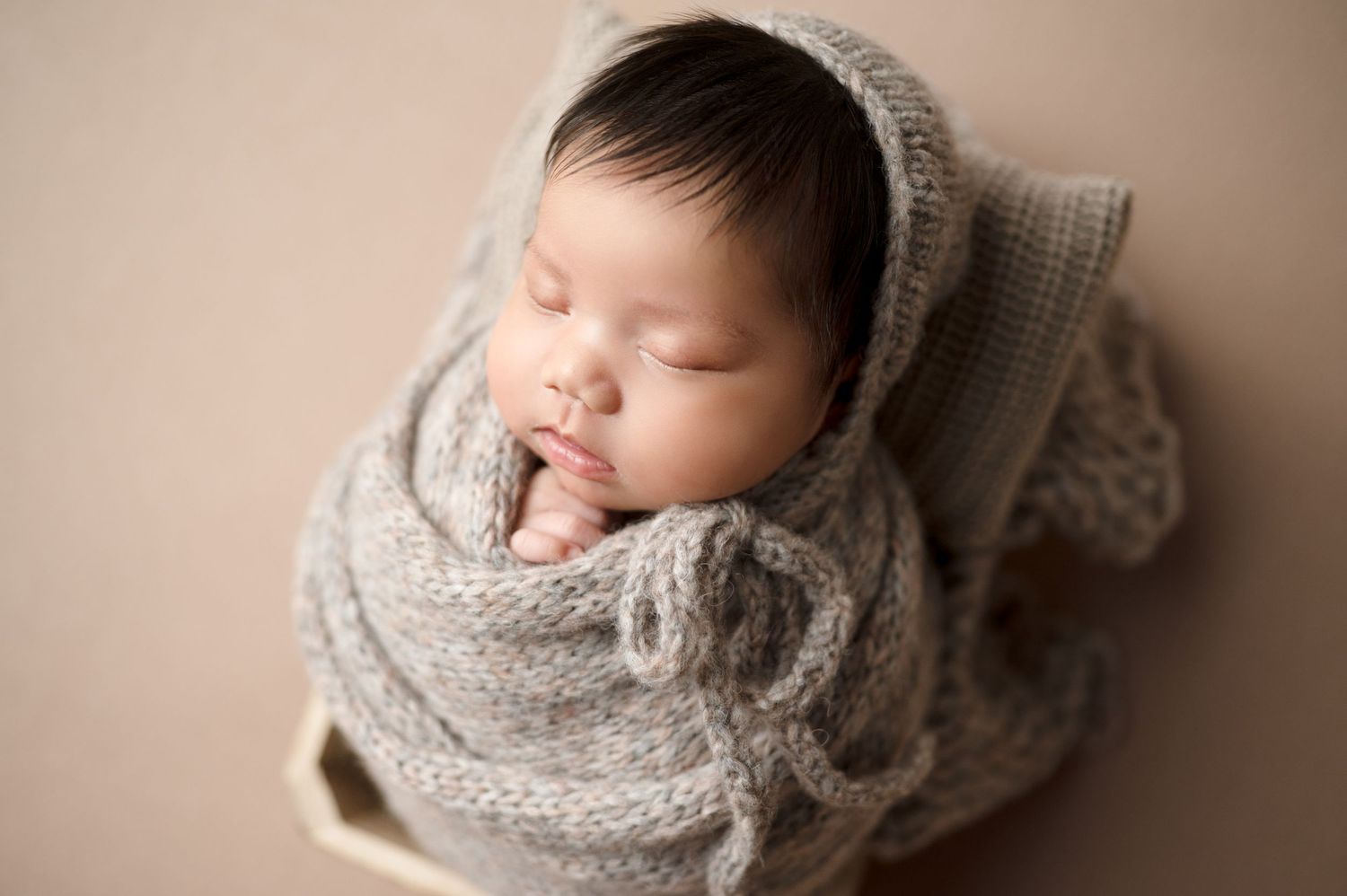 Multiple angles of sleeping newborn wrapped in cozy gray knit cocoon.