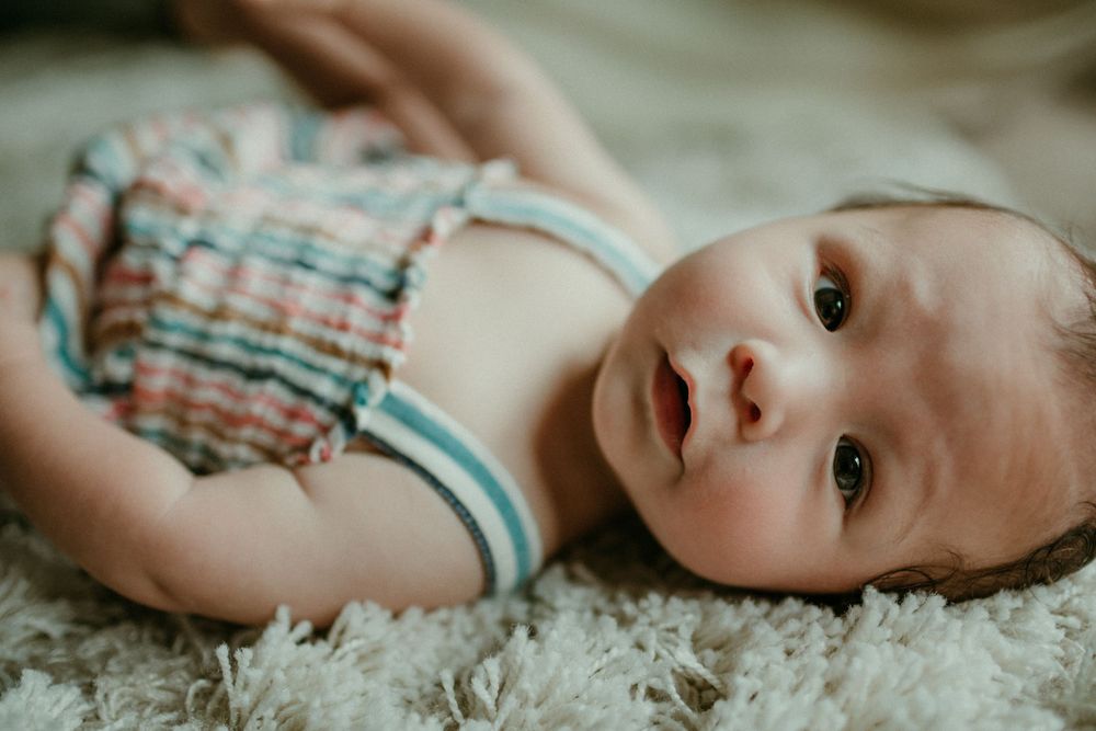 baby looking at camera in home newborn photography session portland oregon