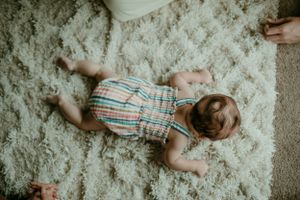 overhead shot of baby scooting on floor in home baby session portland oregon newborn photographer