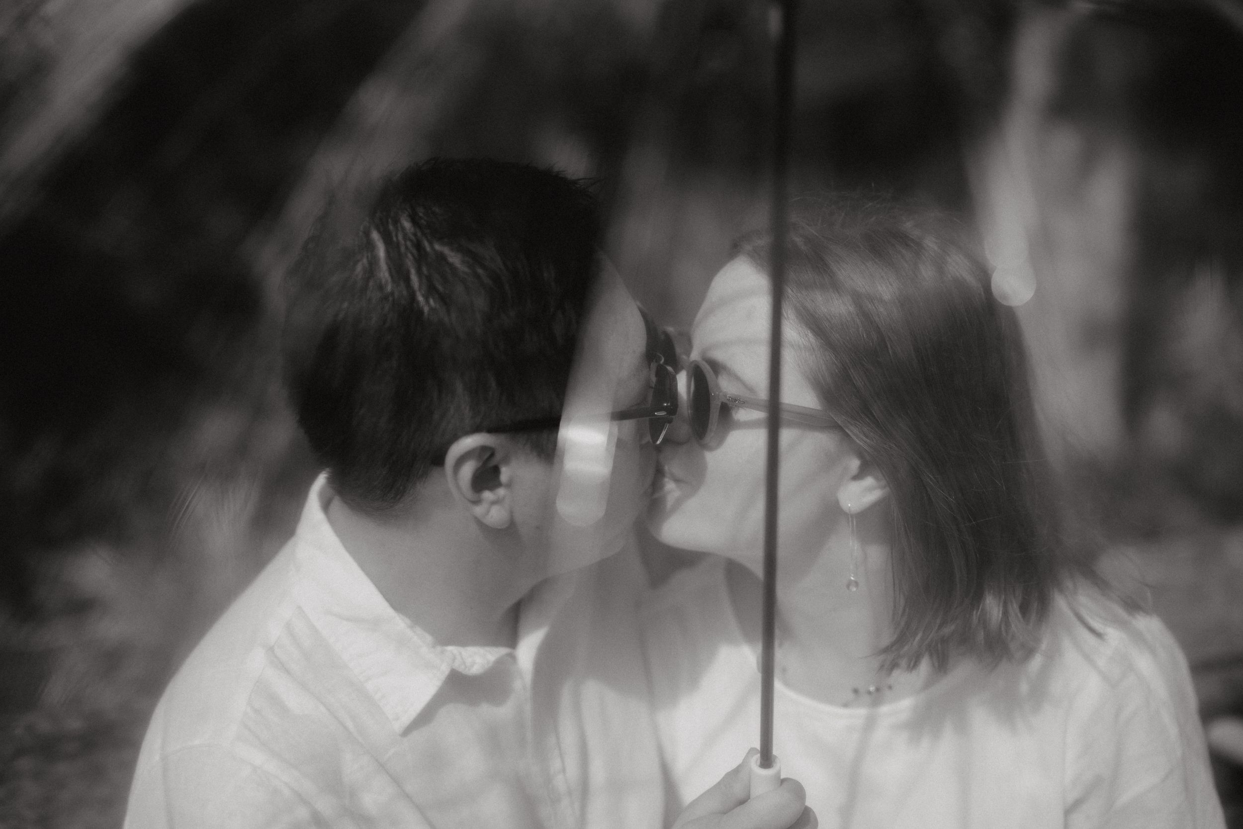 Kissing under an umbrella during the rain