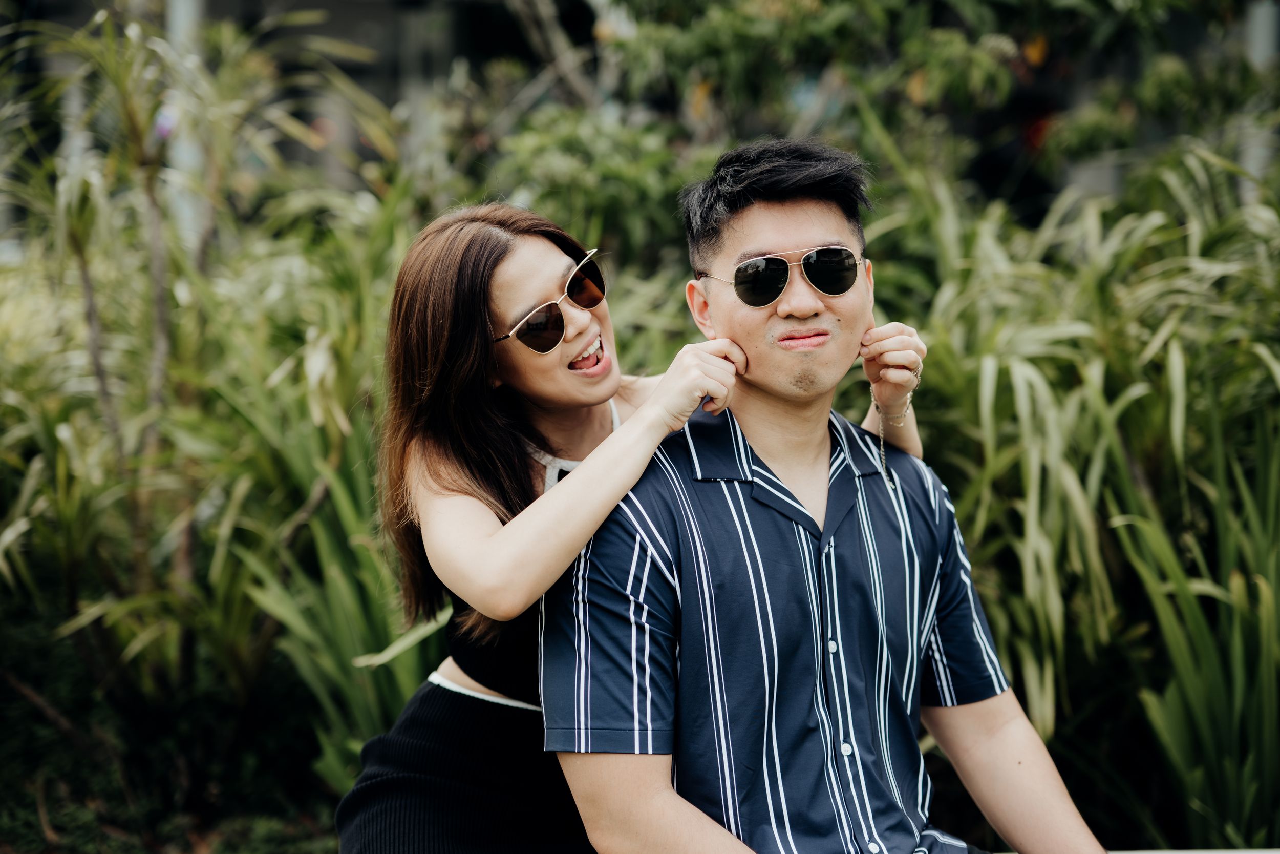 lovable action from girl pinching his cheeks during a couple photoshoot