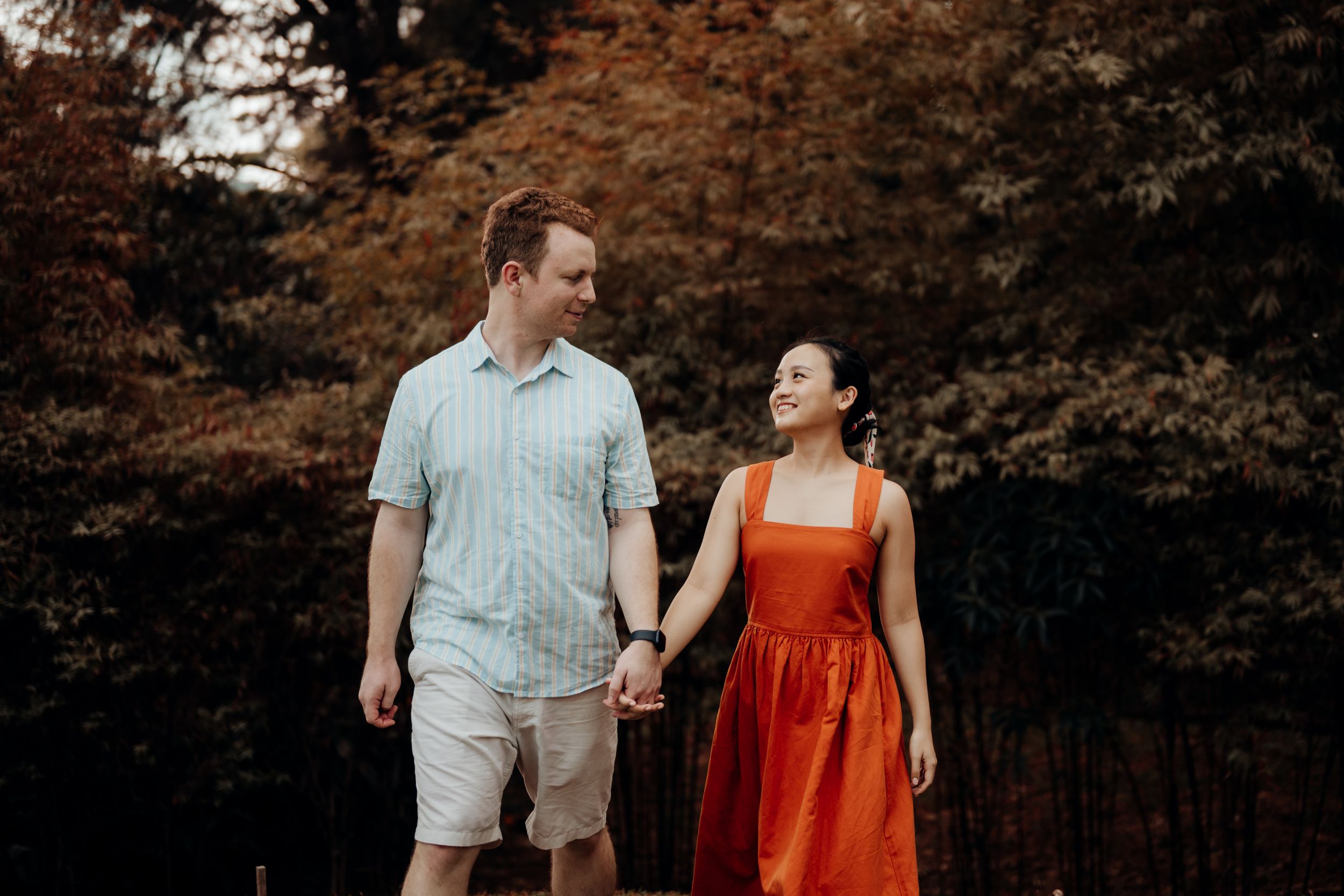 American couple walking together with orange trees at the back