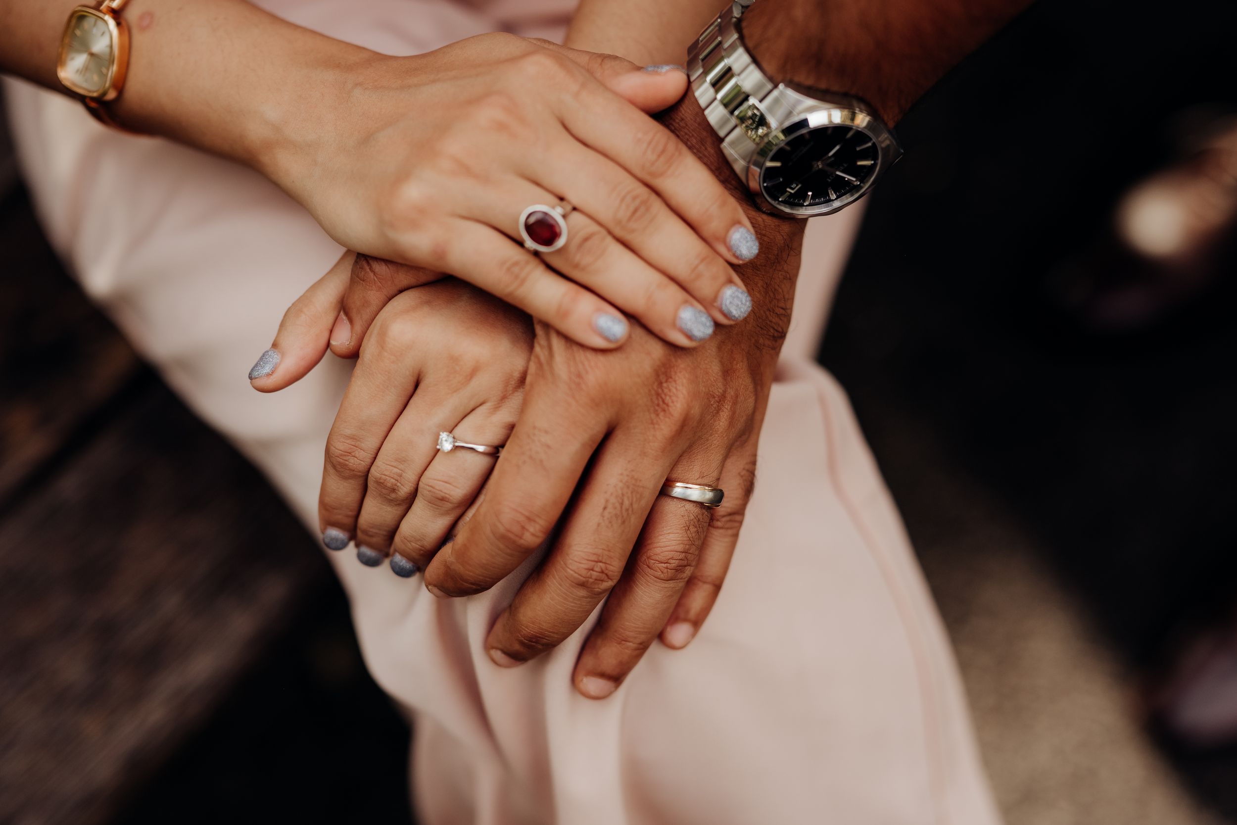 Initimate holding of hands to show their wedding rings