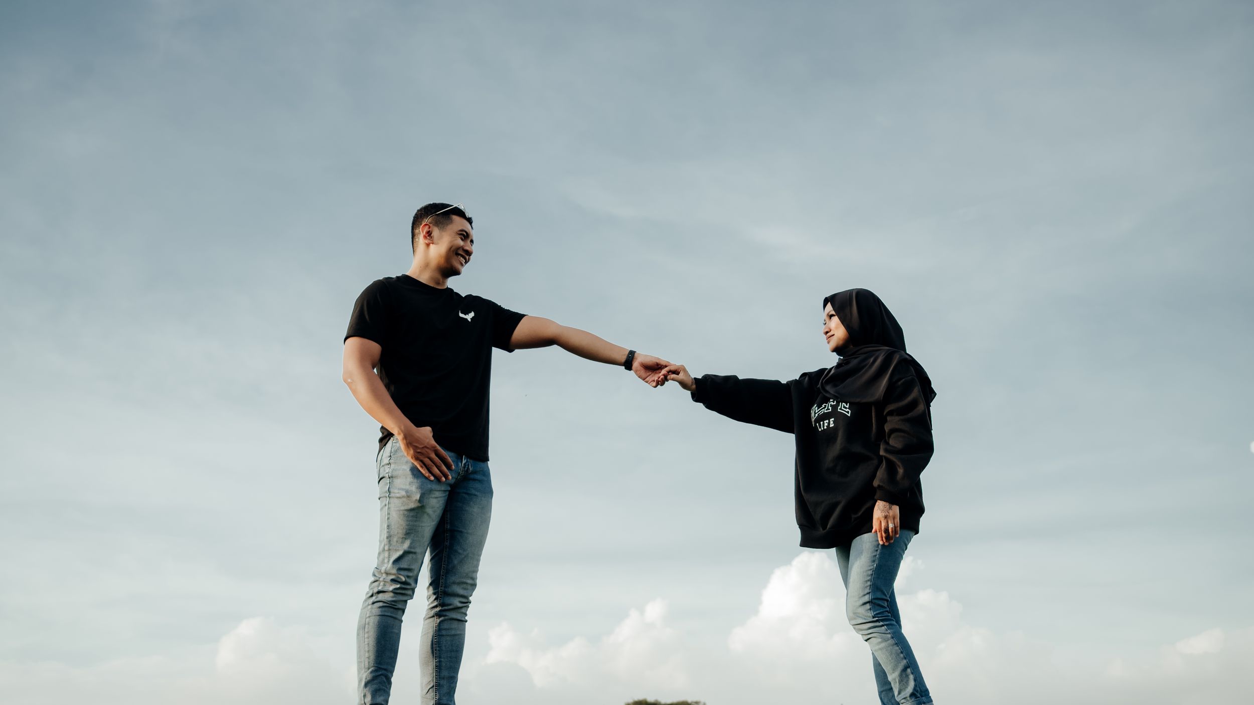 Malay couple dancing with blue sky in the background