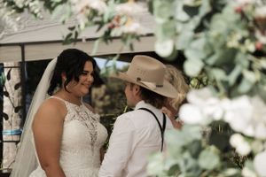 A tender moment between newlyweds during an outdoor wedding ceremony.