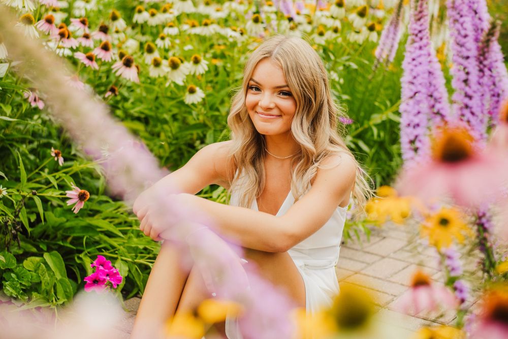 A floral garden setting with pink and yellow flowers in bloom against lush greenery.
