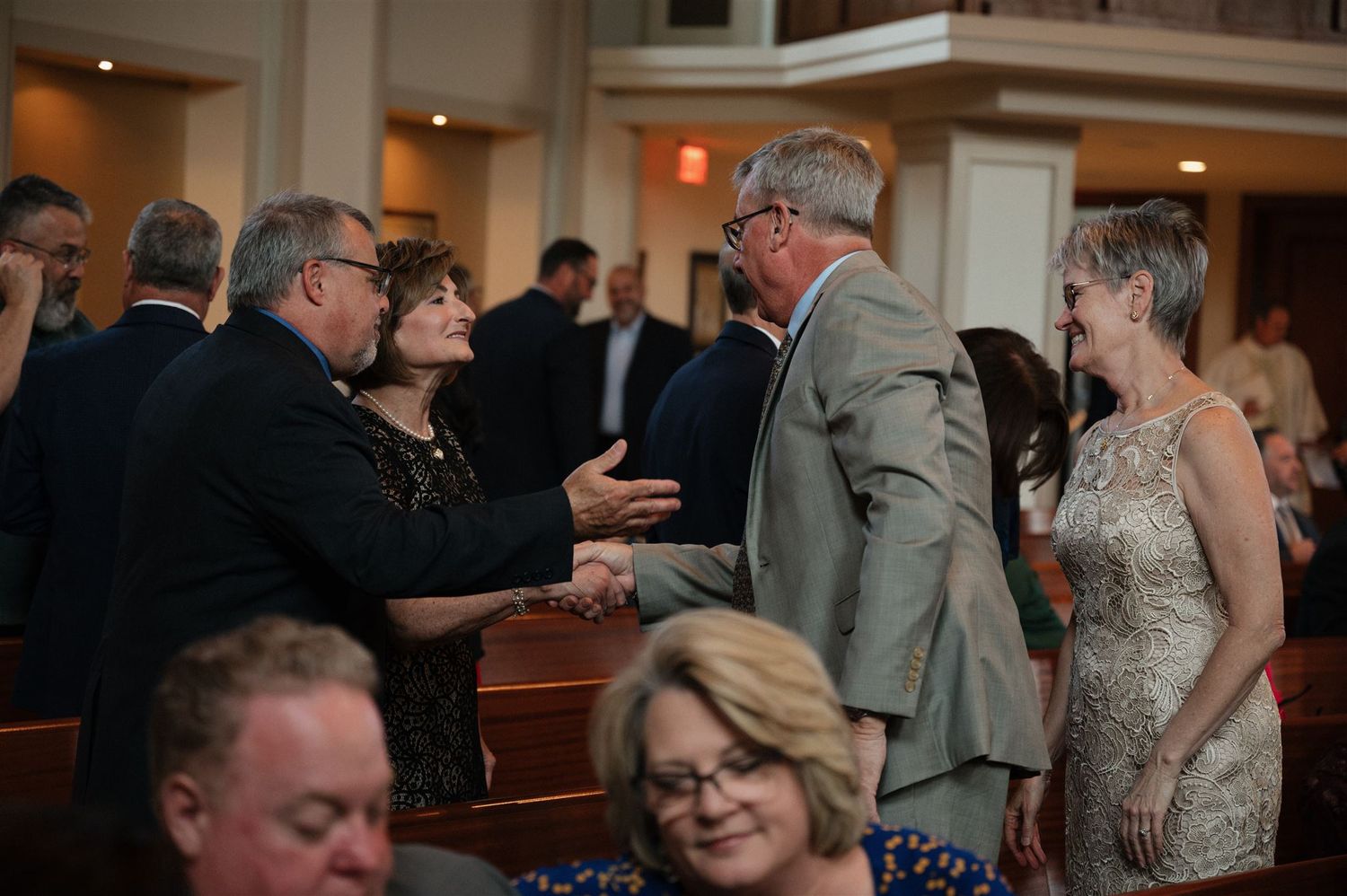 Guests socializing during a formal event in an elegant church reception space.