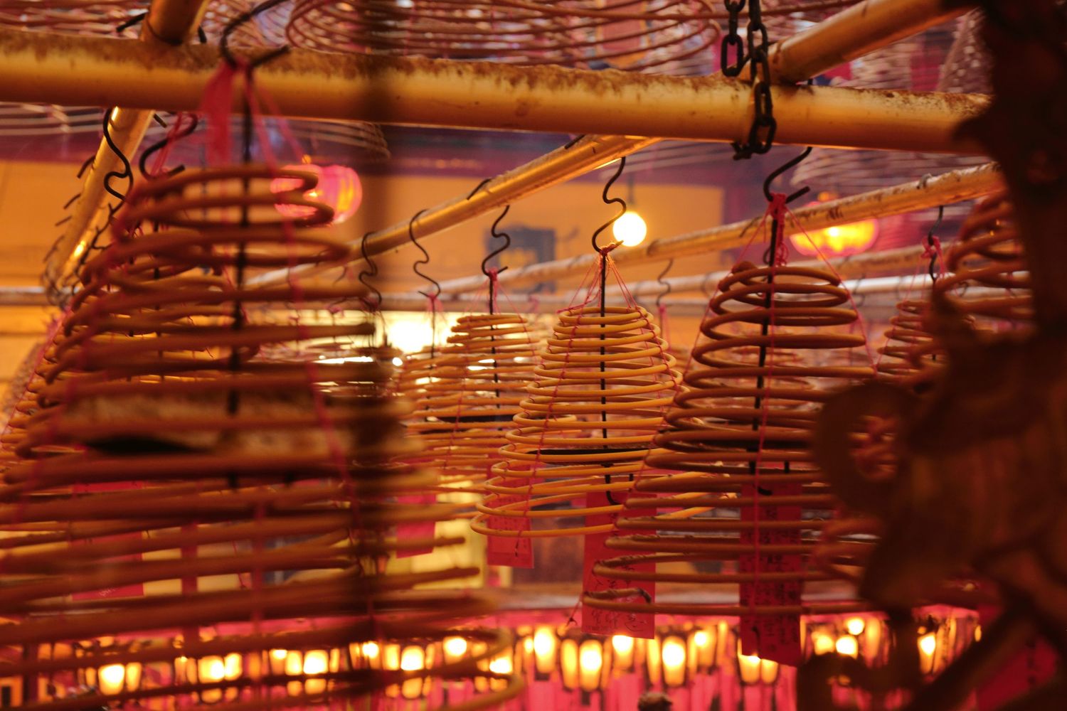 Traditional Chinese hanging lanterns and bamboo decorations illuminated at night.
