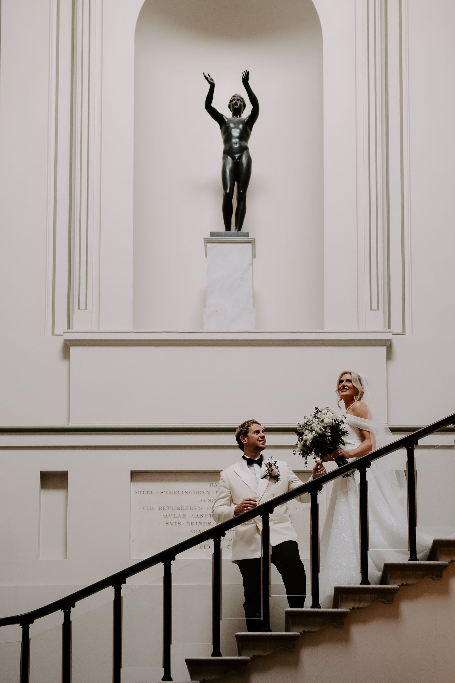 bride and groom descending stairs after wedding ceremony at the Ashmolean Museum