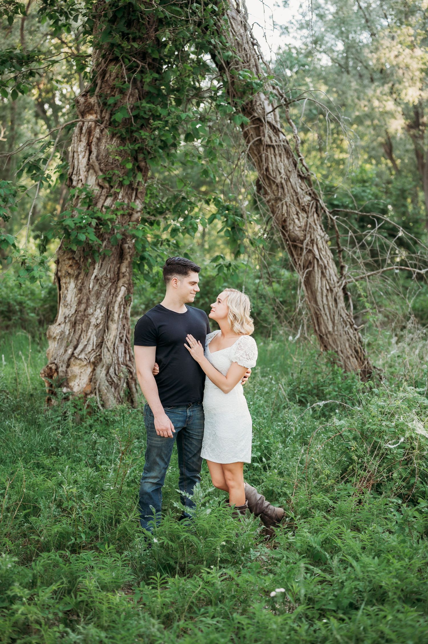 Couple hugging and looking at each other in green field in Staten Island, NY