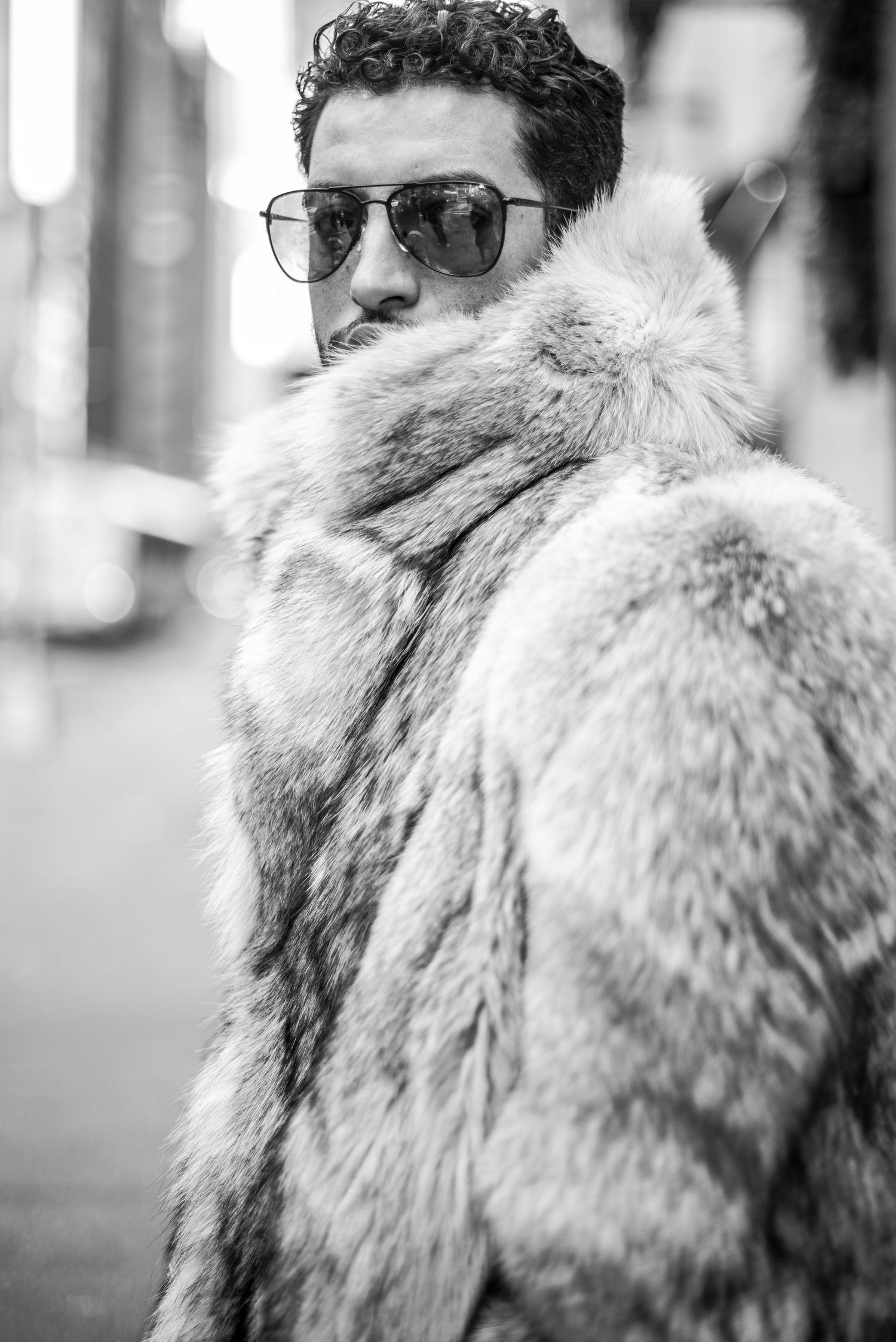Street portrait of a man in fur coat and sunglasses in NYC on 5th Ave
