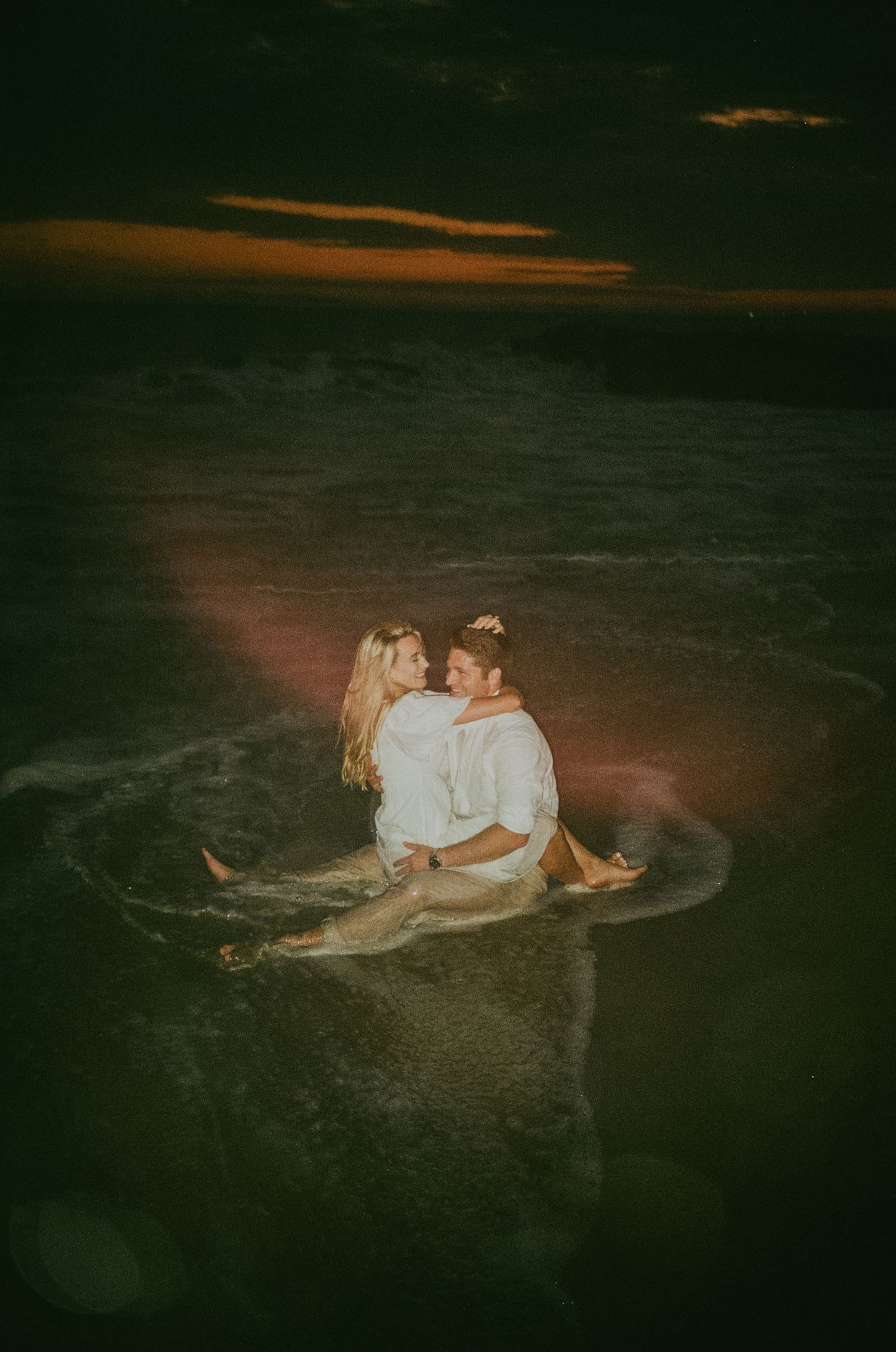 Newport beach sunset couple's engagement shoot on 35mm film camera during blue hour with flash