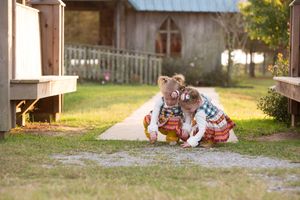 Two children in colorful outfits playing together on garden path.