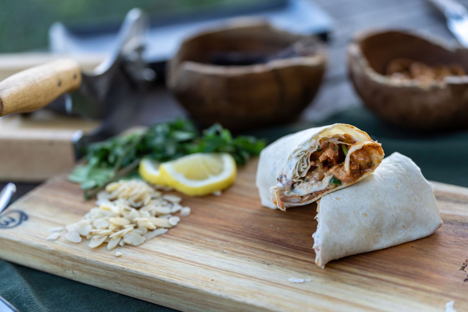 Fresh ingredients and prepared dishes laid out on wooden cutting boards for serving.