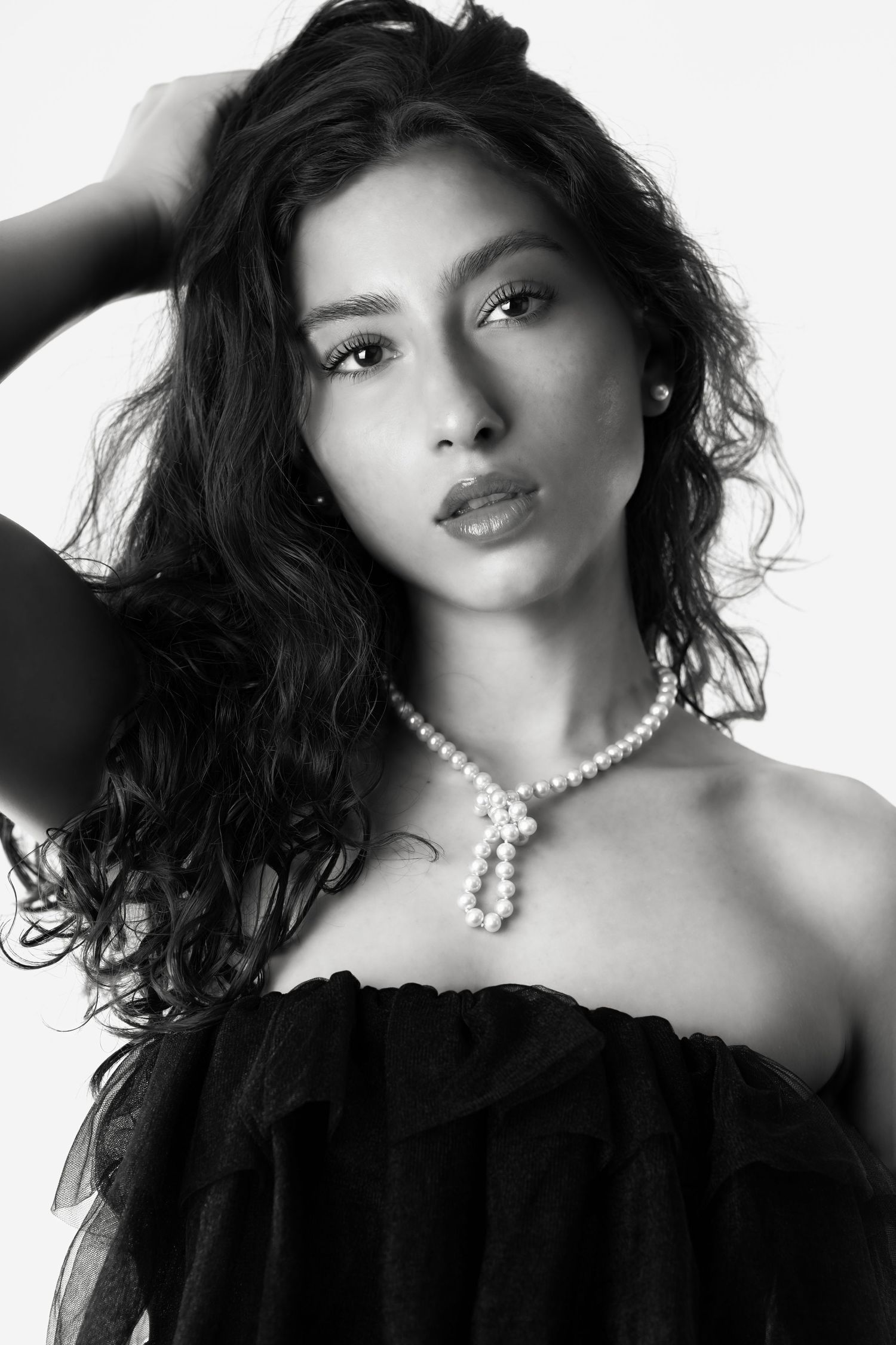 Glamour portraits in black and white featuring pearl necklace and dramatic lighting.