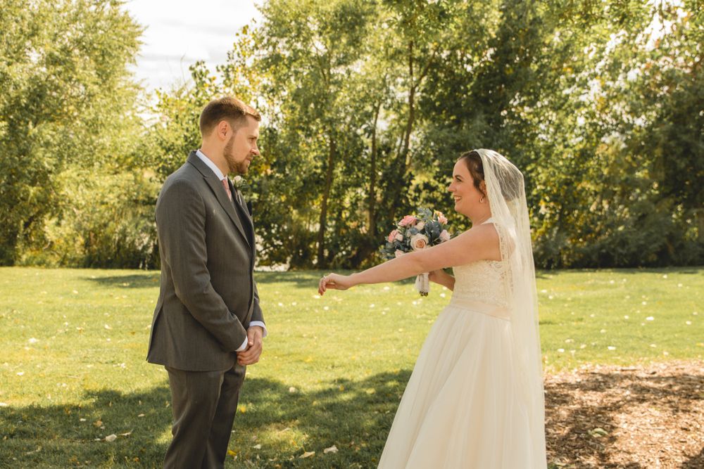 A joyful wedding first look moment captured in a sunlit garden setting.