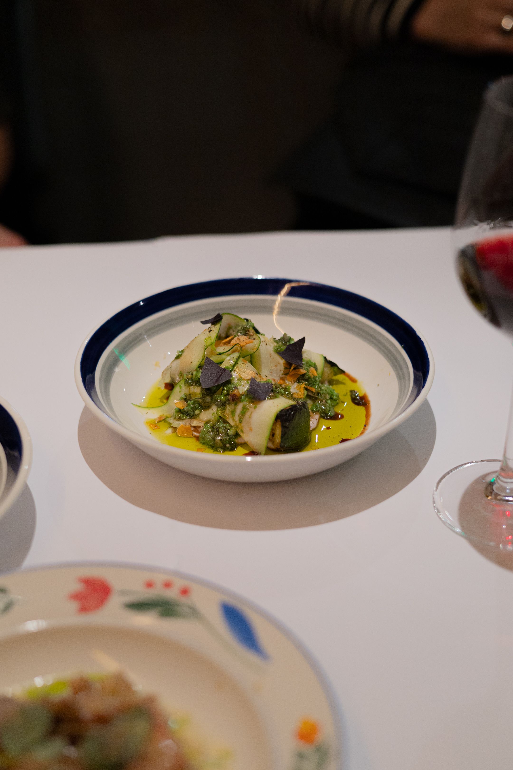 White fish in yellow sauce with fresh herbs served in a navy-rimmed bowl.