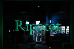 Green neon sign glowing in dark window display.