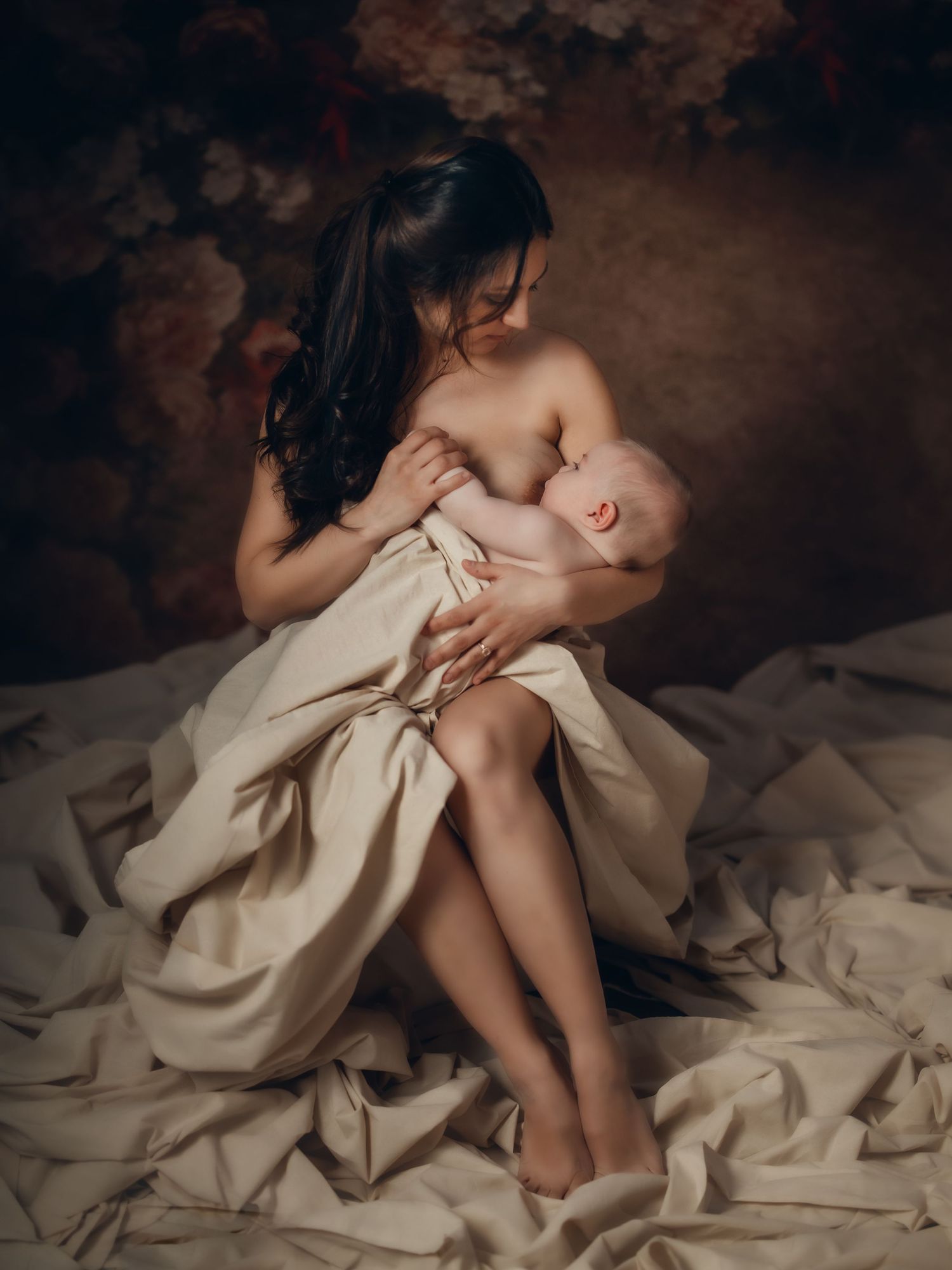 Mother lovingly cradling her baby in a soft, warm-toned maternity portrait. Toronto motherhood photography.