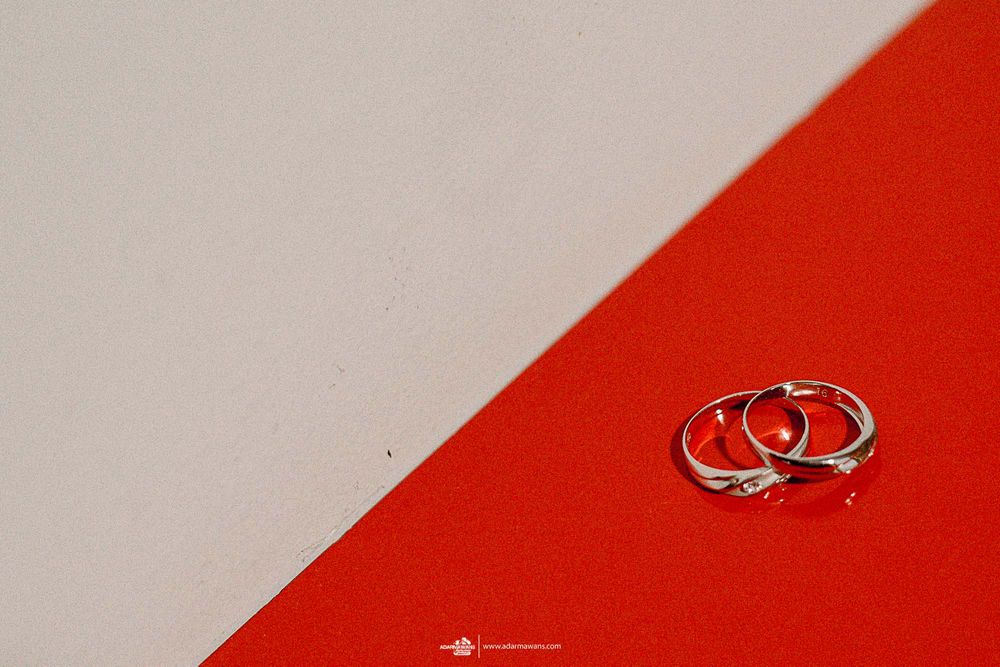 Two silver wedding rings placed on a red and white background.