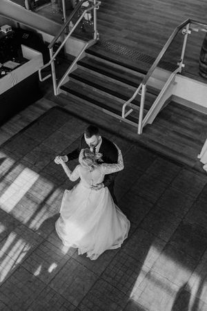 Bride in white dress swings playfully on indoor swings at wedding venue.