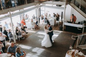 Wedding reception venue with tables and guests in bright modern space.