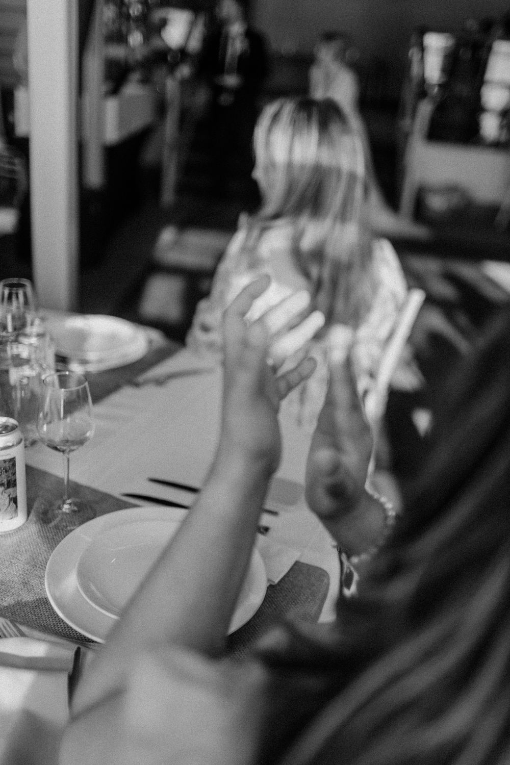 Black and white image of wedding reception table settings with wine glasses.