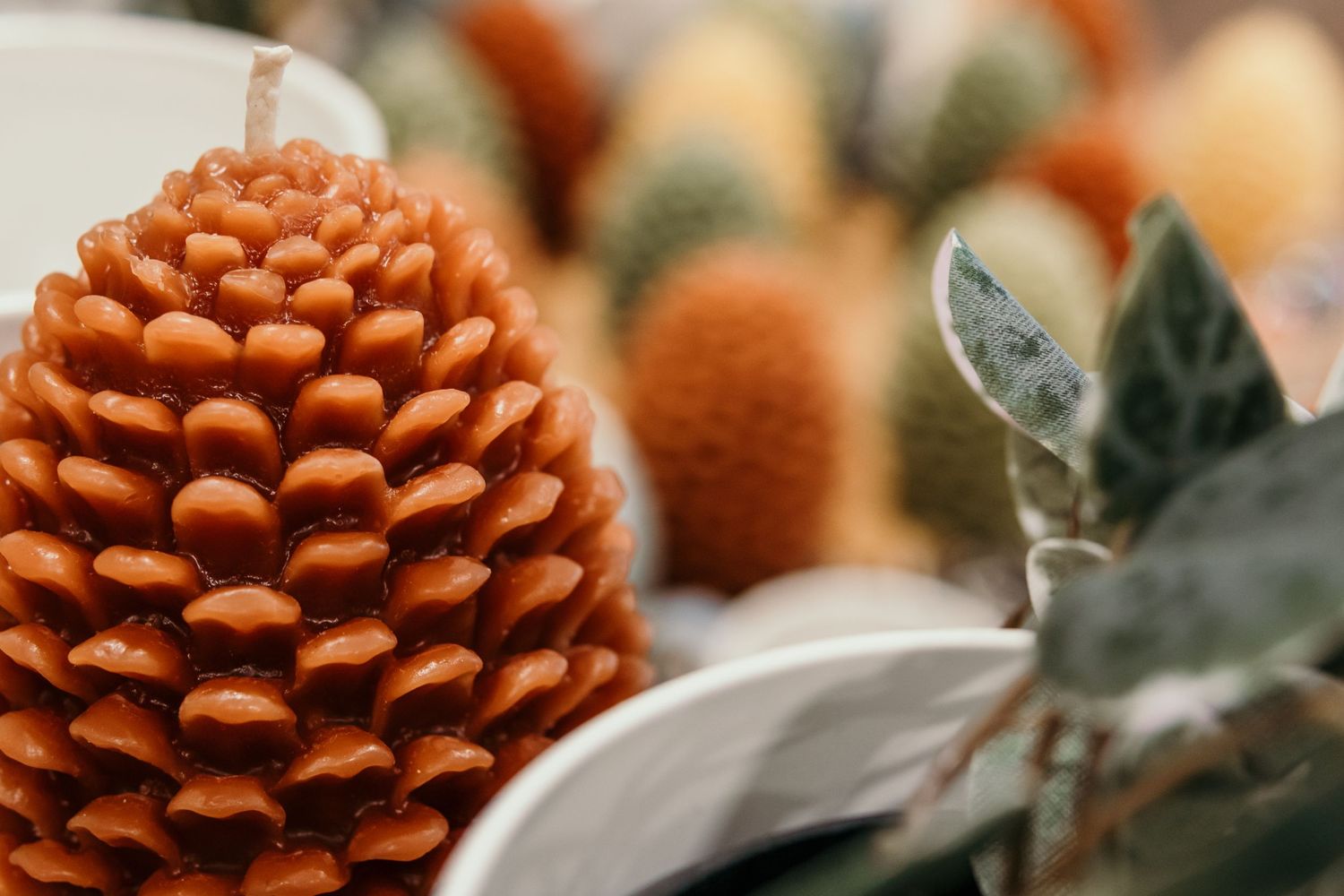 Close-up of orange pinecone decoration with soft focus natural background.