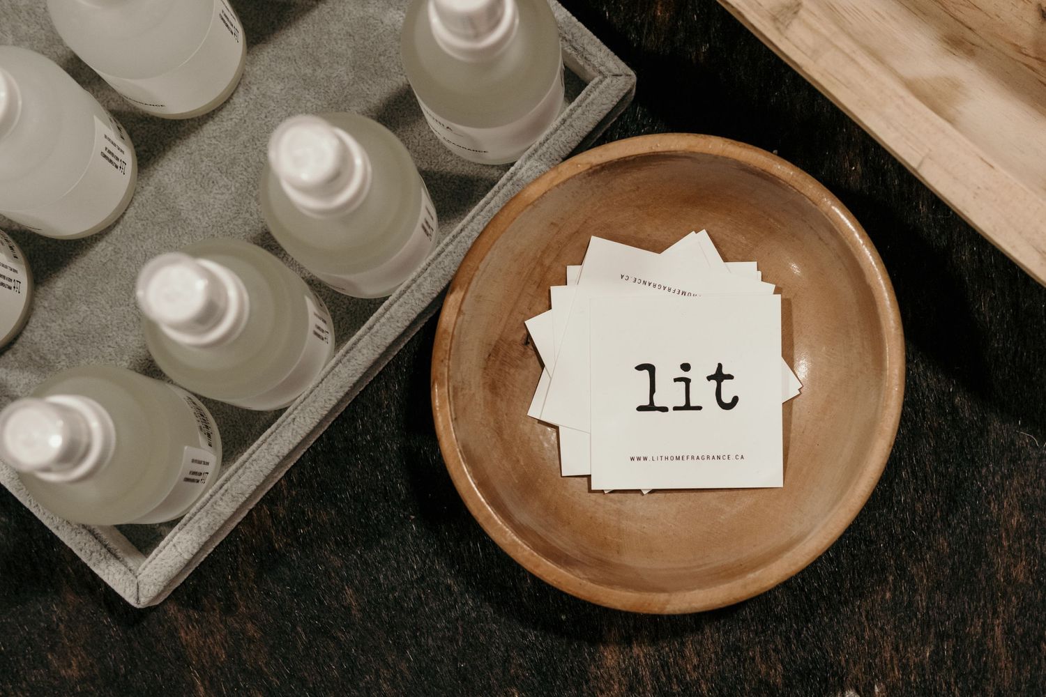 Small glass vials with white labels arranged in rows on a dark wooden surface.