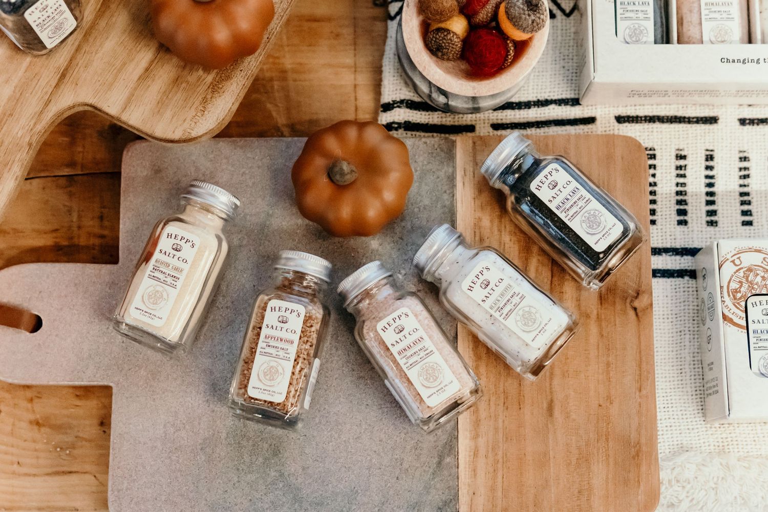 Vintage-style glass bottles and decorative orange pumpkins arranged on wooden surface.