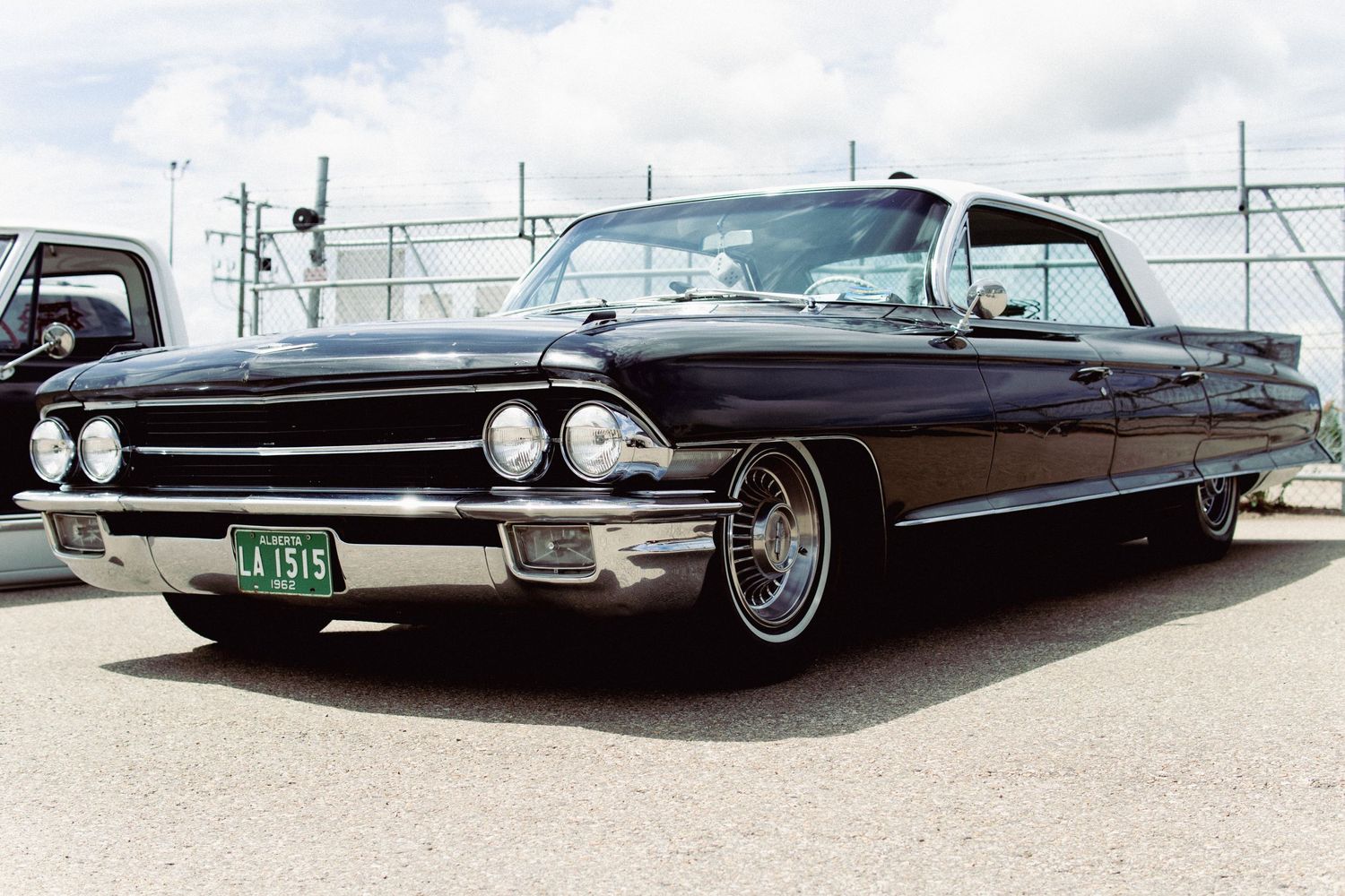 Custom lowrider classic cars displayed at a car show with chrome wheels and custom paint.