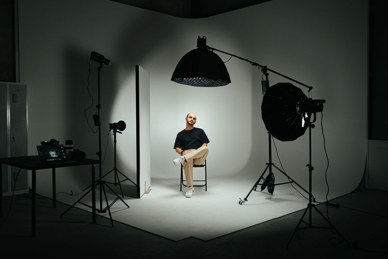 Photography studio setup with lighting equipment and chair in monochromatic setting.