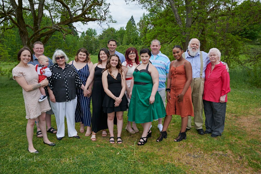 Wedding at Fort Steilacoom Park, Lakewood, WA.  Family photo of wedding guests with trees and sky in background