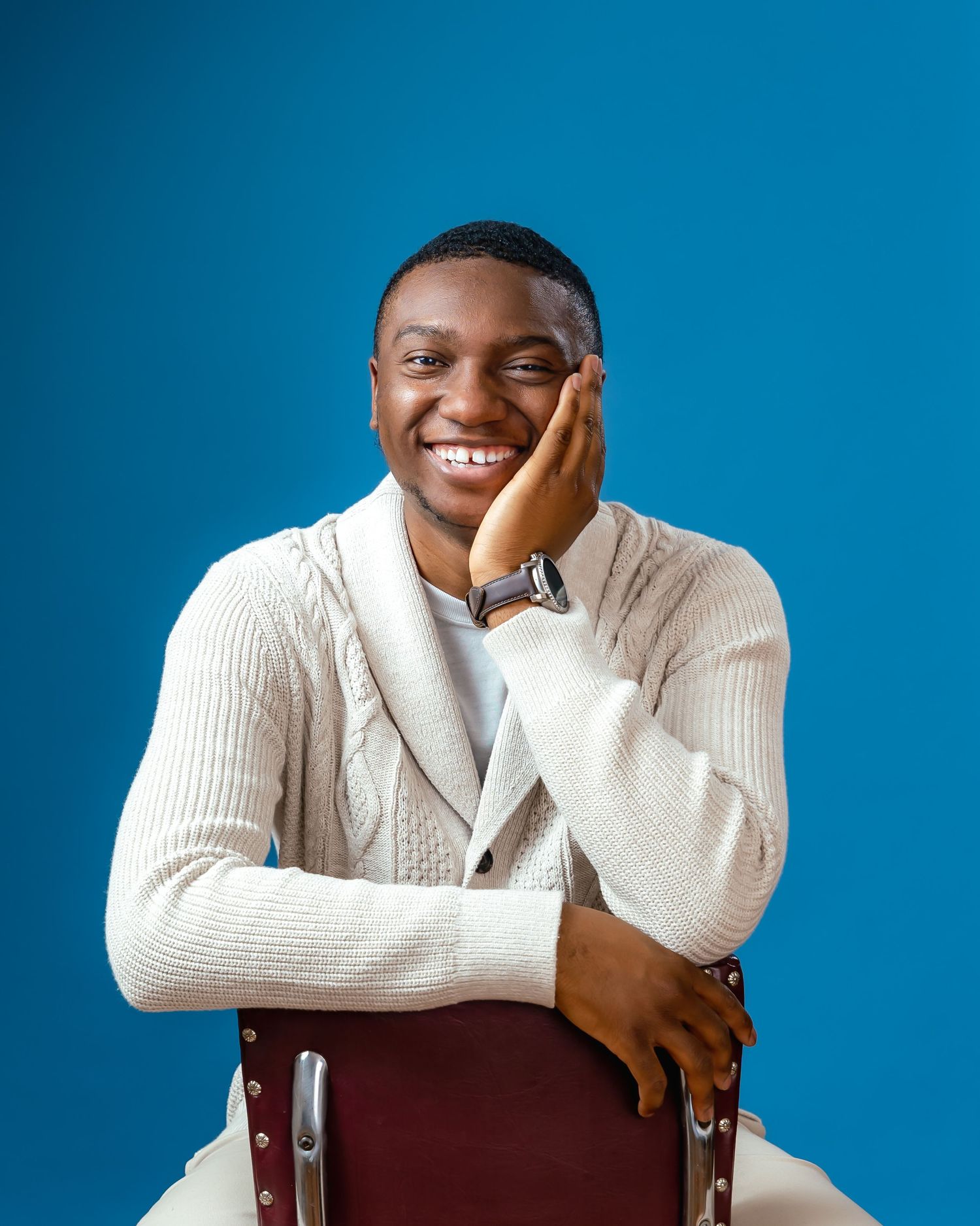 Portrait of a young man in front of a blue background smiling