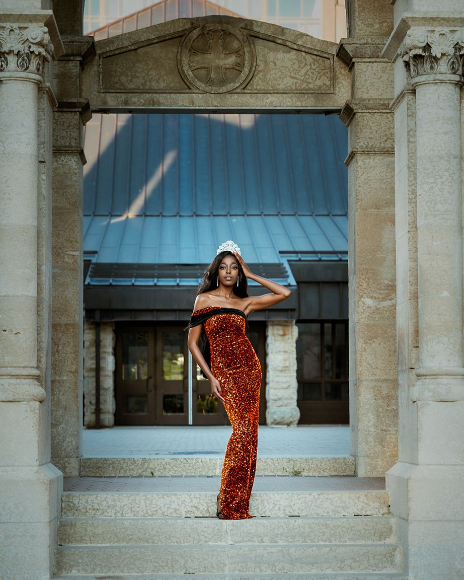 Young girl wearing a beautiful dress and a crown posing elegantly