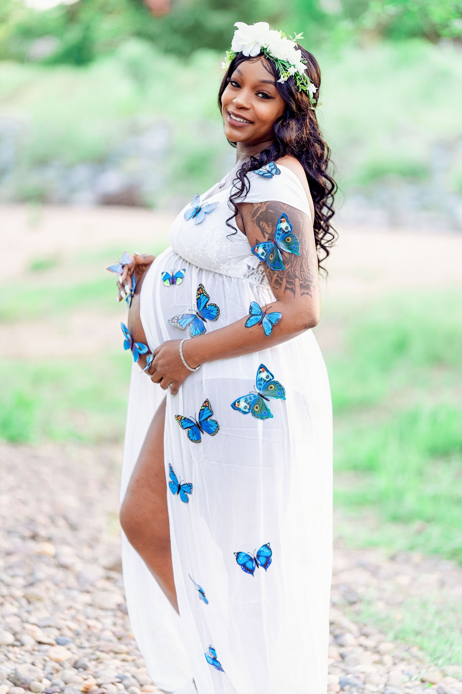 A breathtaking maternity photo of a glowing mother-to-be standing in a sun-drenched field, her silhouette highlighted by soft, golden light.