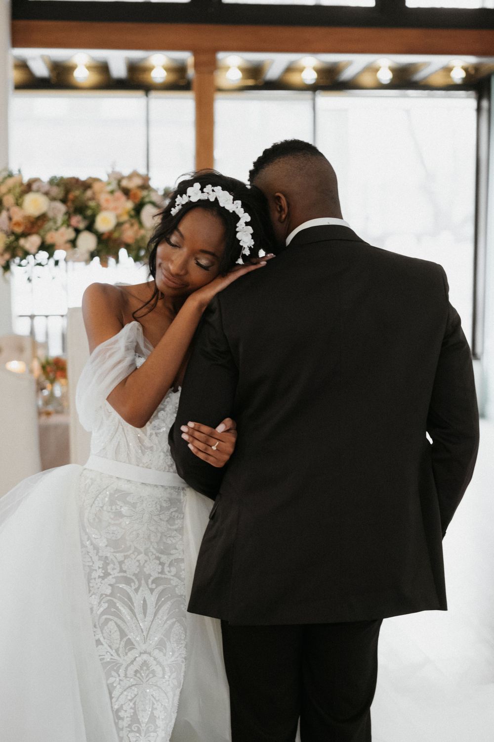 An intimate wedding moment captured with floral decorations in an elegant venue.