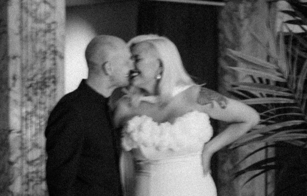 A romantic black and white wedding photo showing a tender moment between newlyweds.