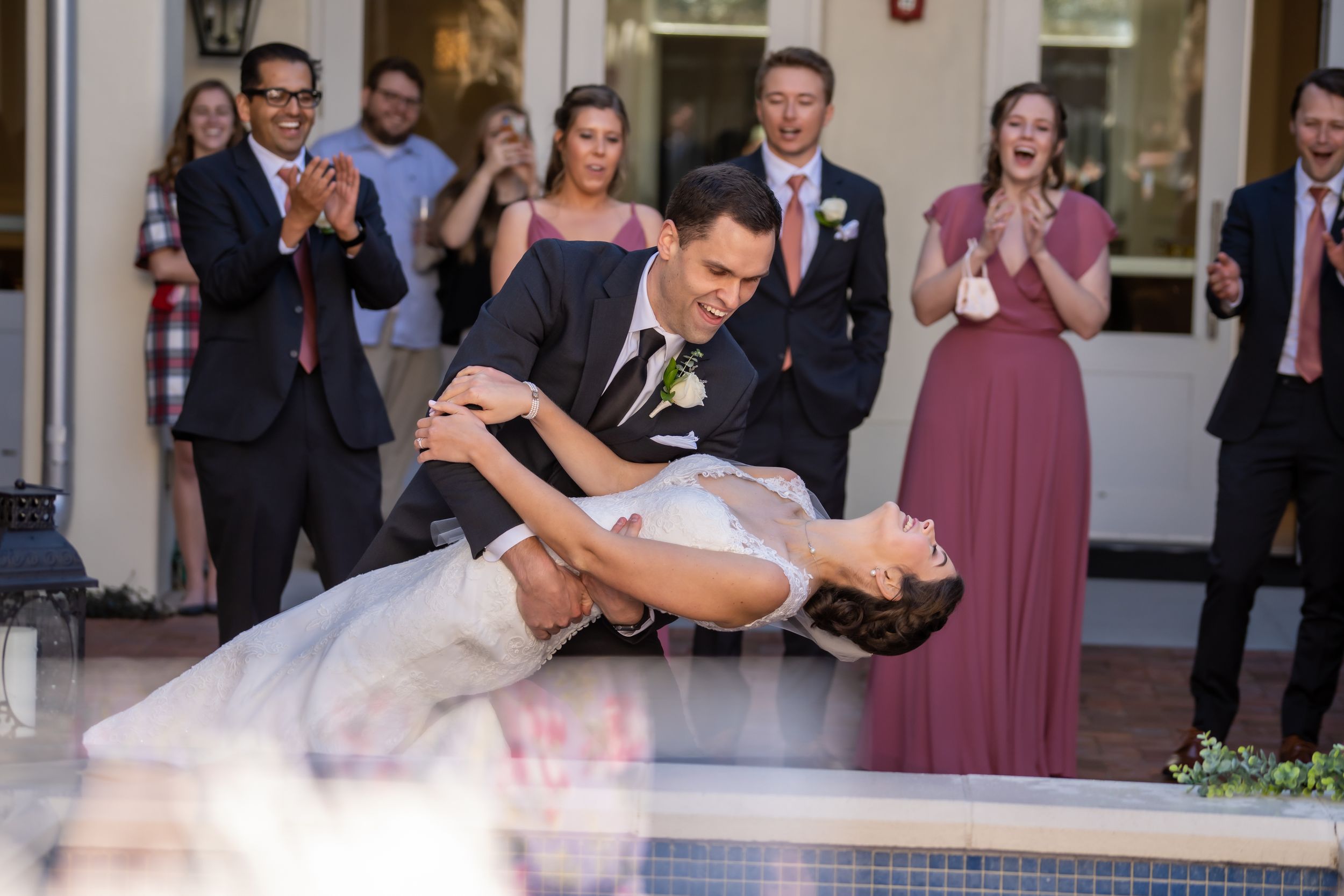 Newlyweds perform romantic dip dance move at wedding reception.