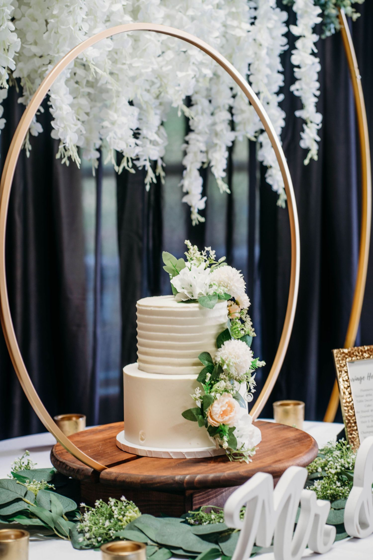 a white cake on a circular stand at a wedding