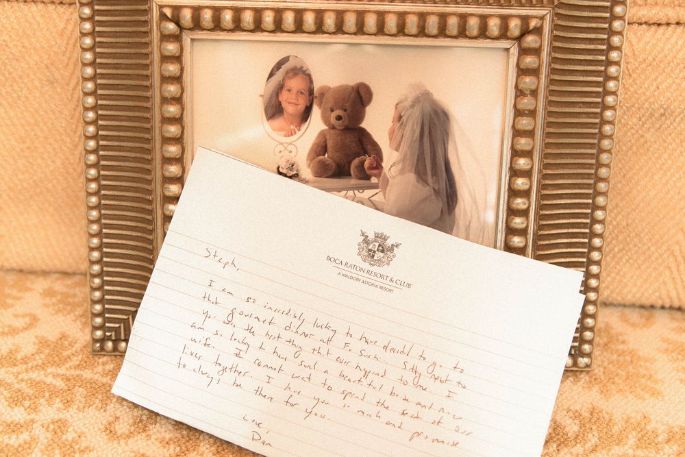 A framed photograph displayed alongside a handwritten letter or note on a textured beige background.