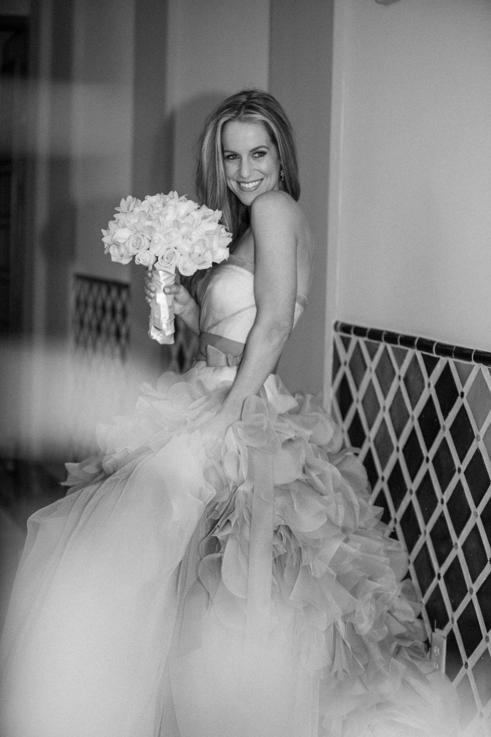 Black and white photo collection showing bridal gown details with dramatic tulle ruffles and floral bouquet.