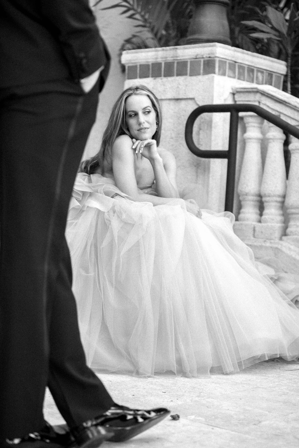 Black and white wedding photo series showing closeup details of dress and shoes on stone steps.