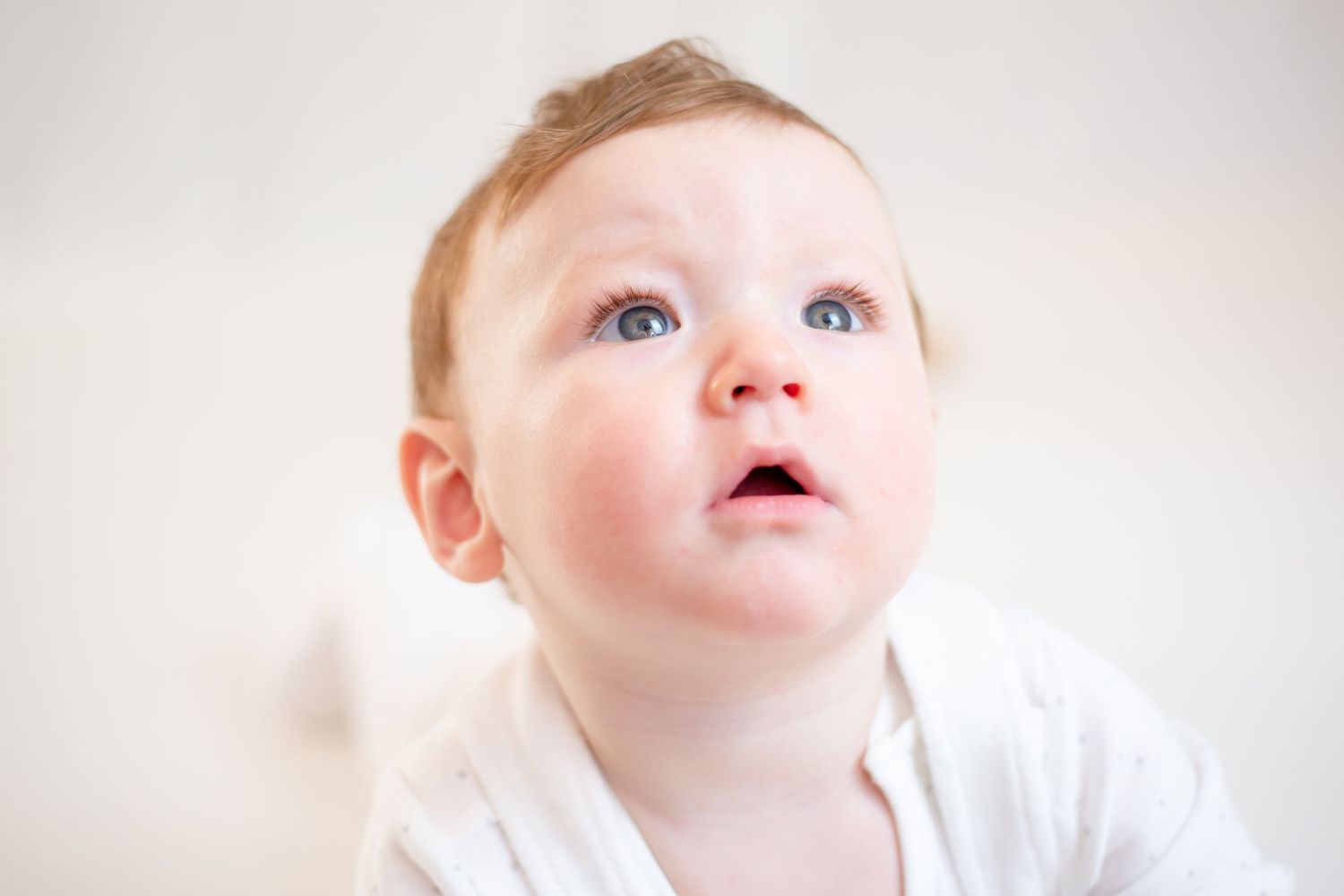 photo of baby boy looking up to the light on his tummy