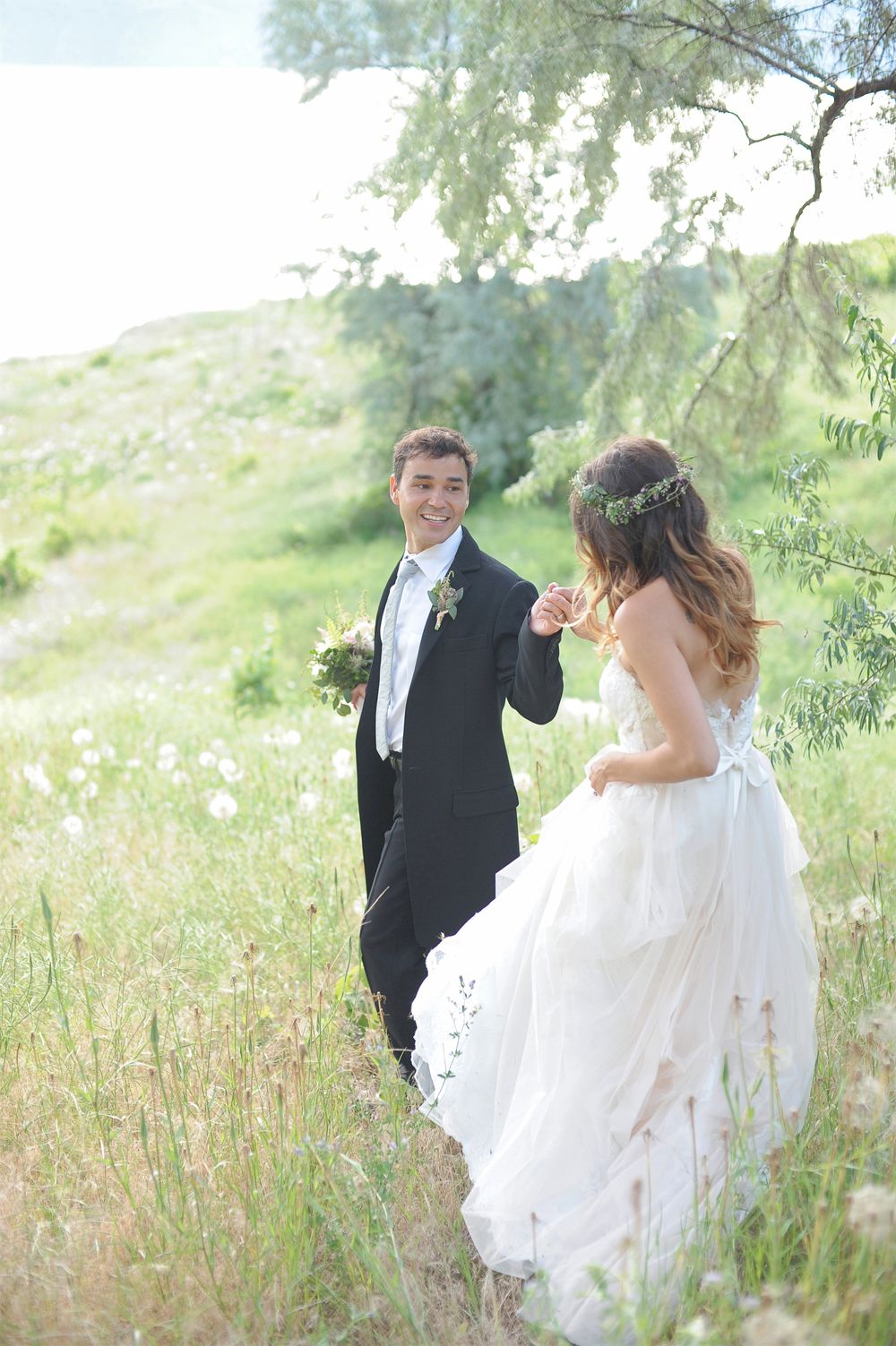 A romantic wedding photo of a couple in a sunlit meadow with flowing white dress at God's Mountain Estate, Penticton, B.C.